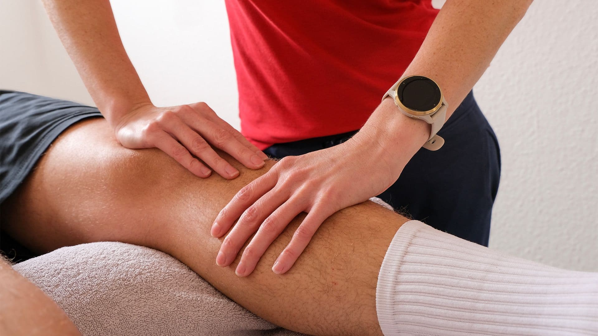 Physiotherapeut behandelt das Knie einer Patientin